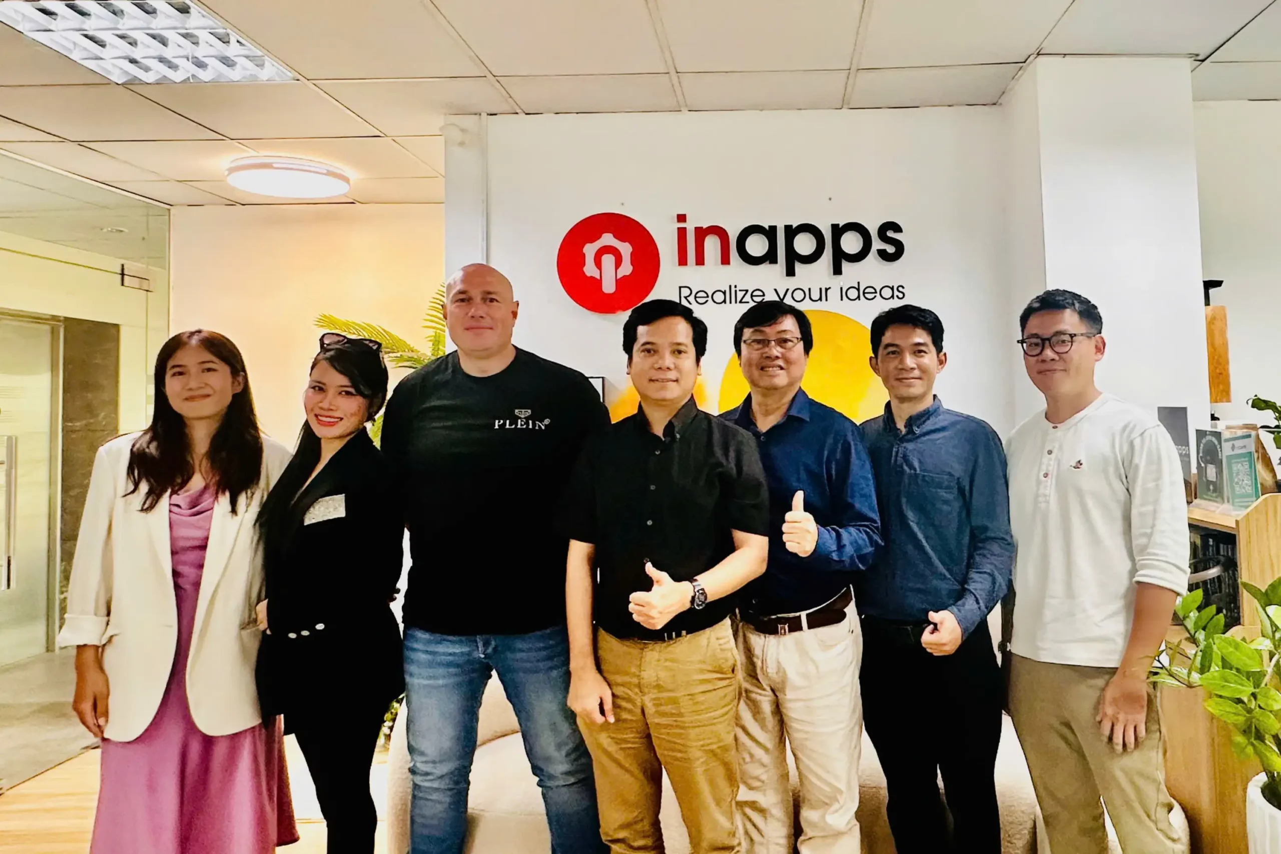 The InApps team photographed in front of the company logo wall at the Ho Chi Minh City office